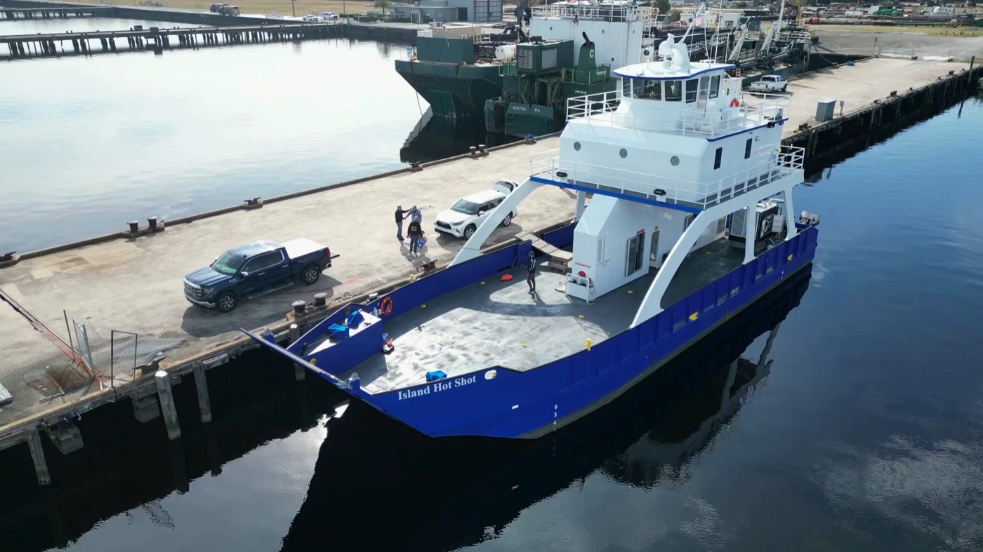 Aerial view of the Island Hot Shot alongside a dock with a pickup truck on the deck