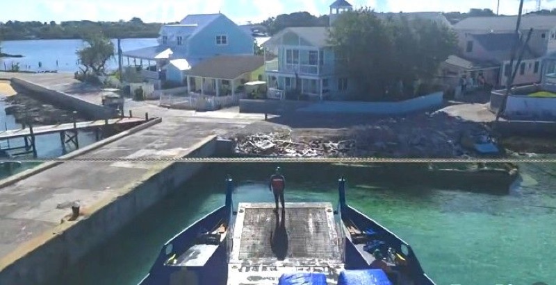 Aerial view of the bow ramp coming down at a small island dock beside waterfront houses